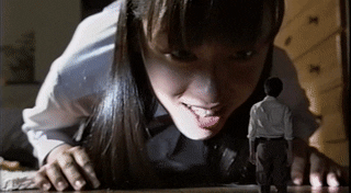 Japanese girl on the floor reaching forward and flicking a shrunken boy, who falls backward
